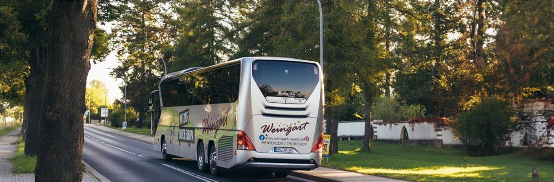 Silberner Weingartbus von hinten, fährt die Straße entlang